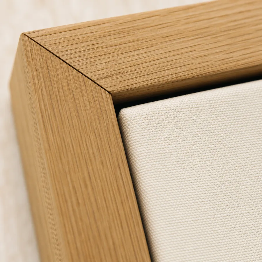 The mitred corner of an oak frame around a canvas